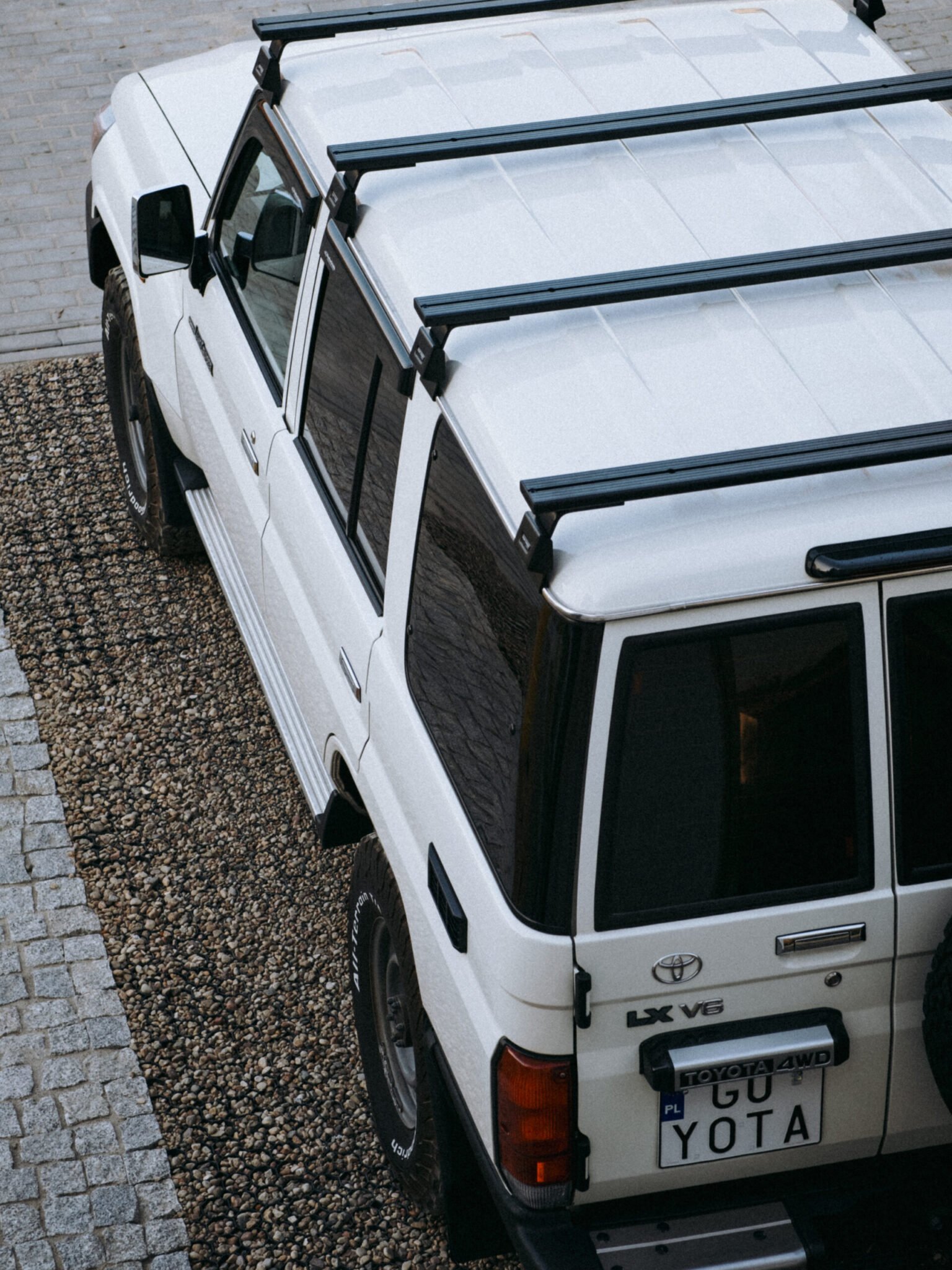 White Toyota Land Cruiser 76 seen from above with four Front Runner load bars across the roof