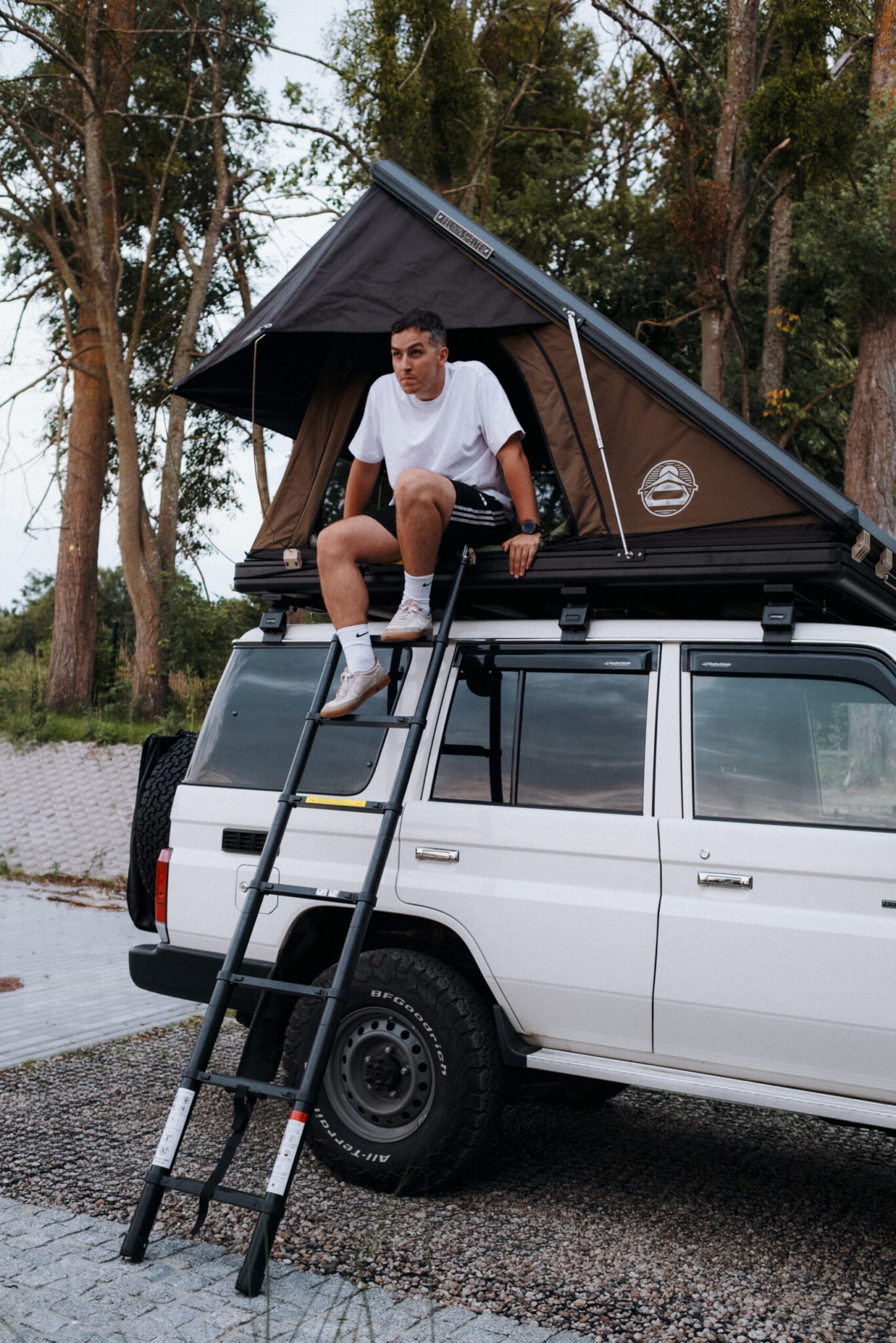 Climbing the ladder into the open Hawk's Nest V2 Wide on a Land Cruiser 76